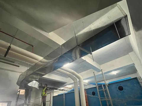 Galvanised ducting run through the double-height plant room