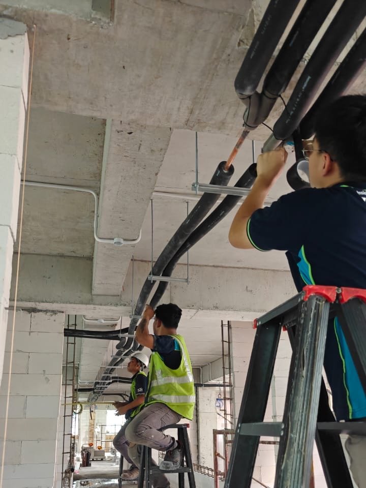 Insulated refrigerant pipe runs suspended under the slab